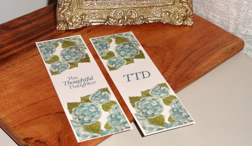 The Thoughtful Daughter hydrangea bookmark set, teal watercolor florals with logo and TTD monogram, double-sided aesthetic Christian stationery gift.